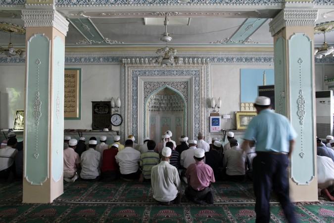 Ethnic Uyghurs pray inside a mosque