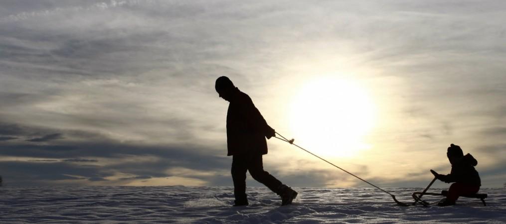 A man trails a child on his sledge during a sunny winter day near Kempten November 20, 2007. Father's Day