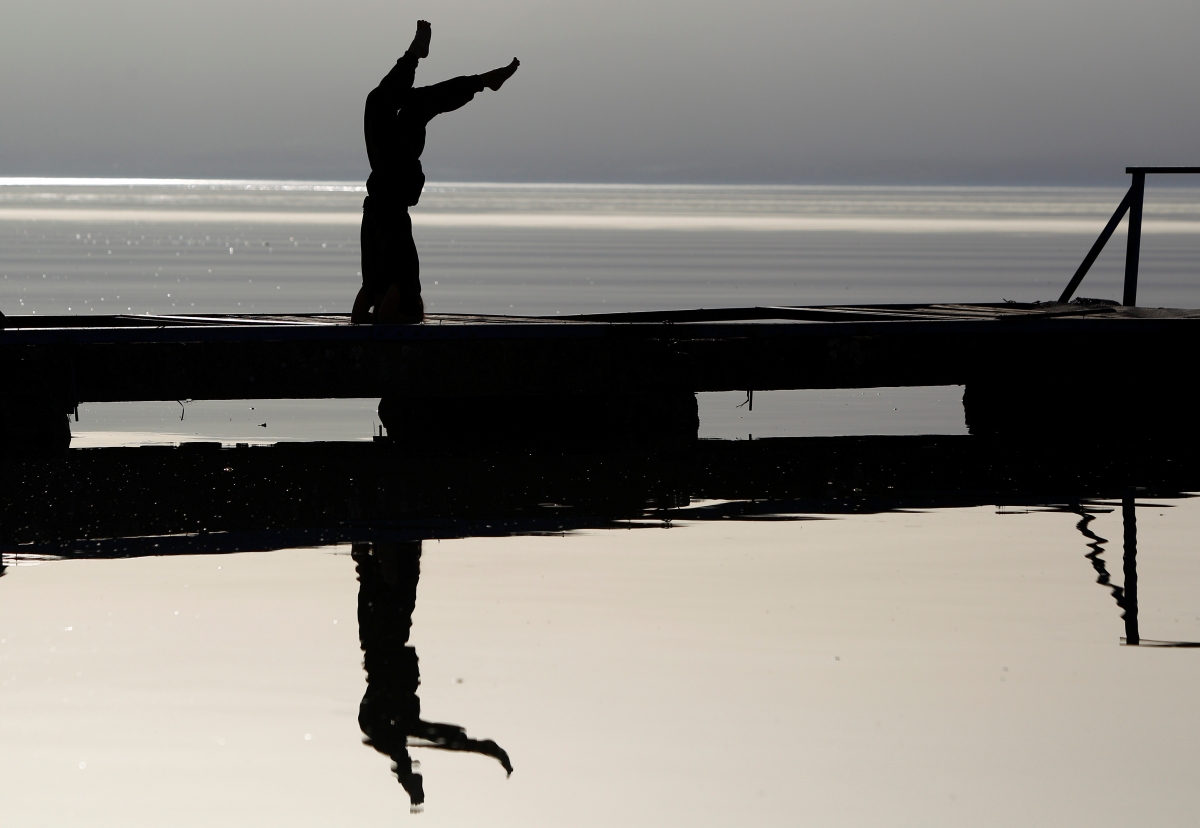 A girl practices yoga on the banks of Lake Ohrid in Ohrid, Macedonia April 12, 2018. yoga