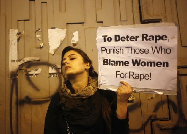 A demonstrator holds a placard as she attends a candlelight vigil to mark the first anniversary of Delhi gang rape, in New Delhi December 16, 2013. Women protesting in Delhi on Nirbhaya gangrape anniversary