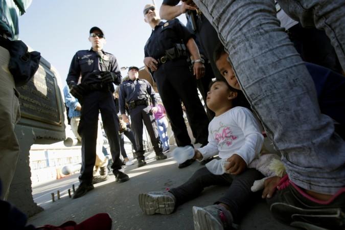 Migrant families from Mexico, fleeing from violence, listen to officers of the U.S. Customs and Border Protection before enter the United States to apply for asylum at Paso del Norte international border crossing bridge in Ciudad Juarez, Mexico June 20, 2018. child separation