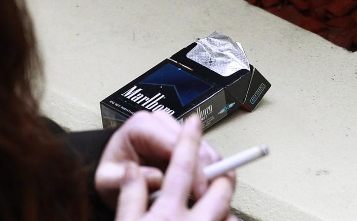 A woman smokes next to a cigarette pack in central Sydney. A woman smokes next to a cigarette pack in central Sydney October 12, 2011.