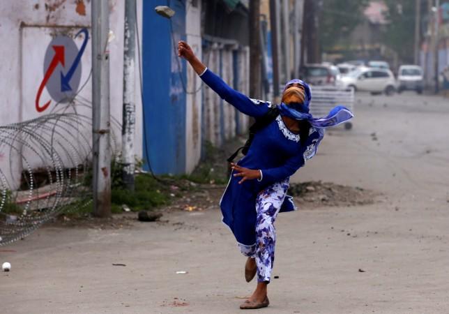 A Kashmiri student throws a stone towards Indian police (unseen) during a protest in Srinagar April 24, 2017. Women have also joined stone pelters. stone pelting