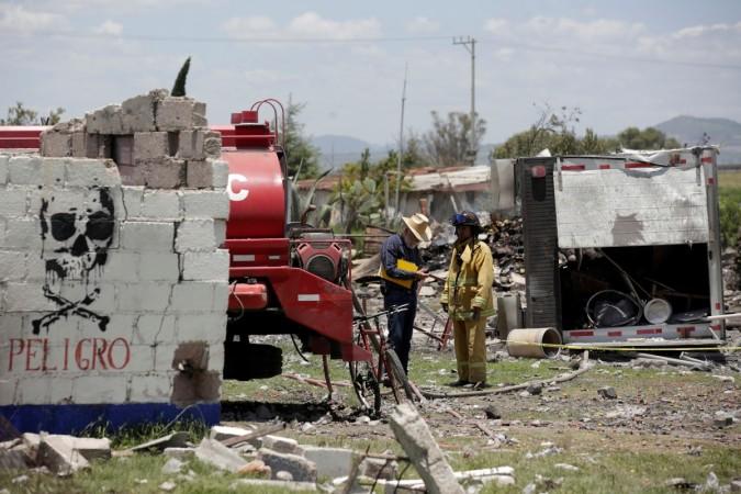 A firefighter talks to a resident at a site damaged due to fireworks explosions in the municipality of Tultepec, on the outskirts of Mexico City, Mexico July 5, 2018. Mexico fireworks blast
