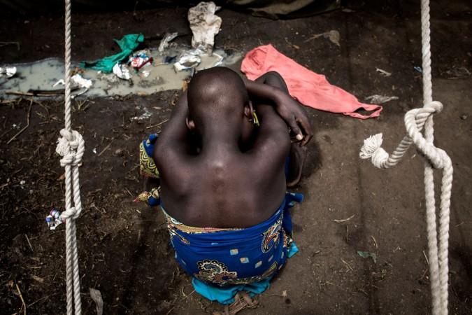 A Internally Displaced Congolese child sits on the ground at a camp for IDP's on February 27, 2018 in Bunia. Twenty-three people have been killed in renewed clashes between ethnic groups in the Democratic Republic of Congo's troubled east, according to an official toll Wednesday. Congo war