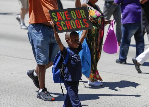 A young activists holds a sign as he march onto Chicago Dan Ryan Expressway to protest violence in the city on July 7, 2018 in Chicago, Illinois. Activists March Onto Chicago Expressway To Protest Violence In the City