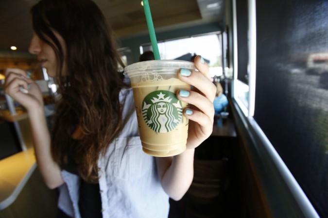 A patron holds an iced beverage at a Starbucks coffee store in Pasadena, California A patron holds an iced beverage at a Starbucks coffee store in Pasadena, California