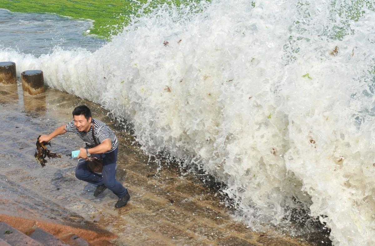 A tourist run away from waves caused by Typhoon Maria Typhoon Maria