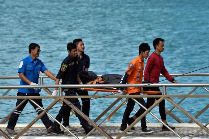 Thai Rescue workers carry the body of a victim on a stretcher, after a boat capsized off the tourist island of Phuket, Thailand Thai Rescue worker