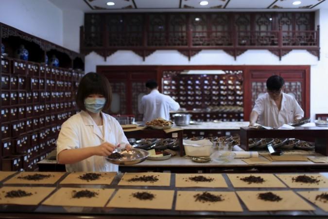 Employees work at a traditional Chinese medicine shop in Shanghai, China, Employees work at a traditional Chinese medicine shop in Shanghai, China,