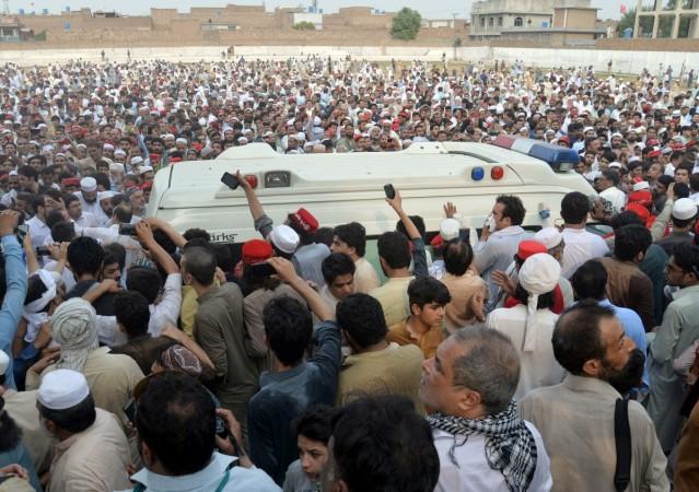 People gather around an ambulance carrying the coffin of Awami National Party (ANP) candidate Haroon Bilour who was killed among others on July 10's suicide attack during an election campaign meeting, in Peshawar, Pakistan July 11, 2018. Pakistan suicide attack