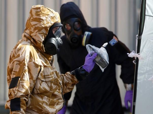Forensic investigators, wearing protective suits, emerge from the rear of John Baker House, after it was confirmed that two people had been poisoned with the nerve-agent Novichok, in Amesbury, Britain, Forensic investigators