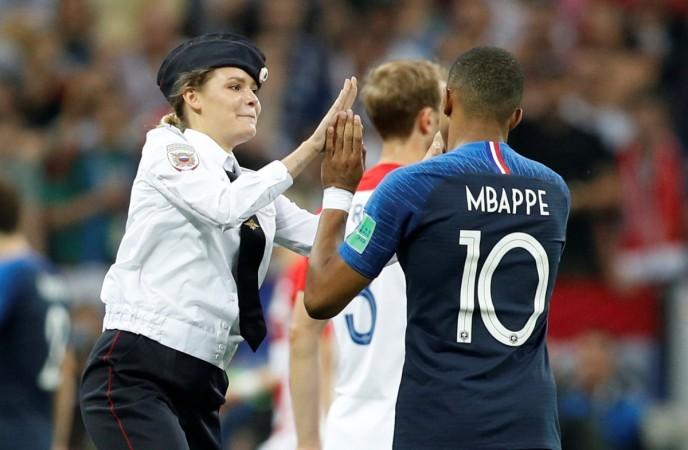One of the four Pussy Riot pitch ivaders gives a high five to France star Kylian Mbappe. Pussy Riot