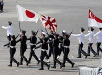 Singapore and Japanese troops march with flags