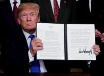 Trump holds his signed memorandum on intellectual property tariffs