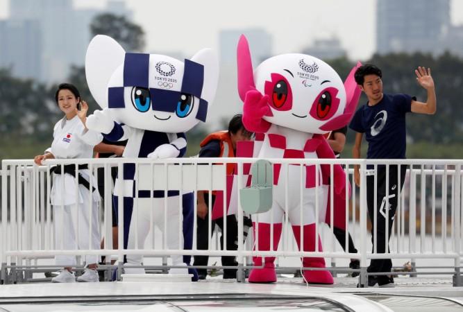 Tokyo 2020 Olympic Games mascot Miraitowa and Paralympic mascot Someity wave with Japan's Paralympic long-jumper Hajimu Ashida and karateka Kiyo Shimkizu atop a cruise ship during their water parade upon their arrival at Odaiba Marine Park in Tokyo, Japan July 22, 2018 Tokyo 2020 Olympic Games mascots