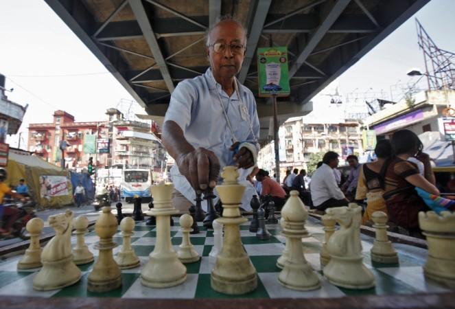 Amlandu Saha, 75, arranges chess before starting to play at an open air street chess club at Gariahat Boulevard in Kolkata November 11, 2013 Amlandu Saha