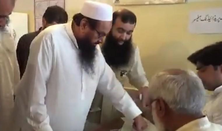 Lashkar-e-Taiba chief and Mumbai 26/11 attacks mastermind Hafiz Saeed casts his vote at a polling booth in Lahore. Hafiz Saeed