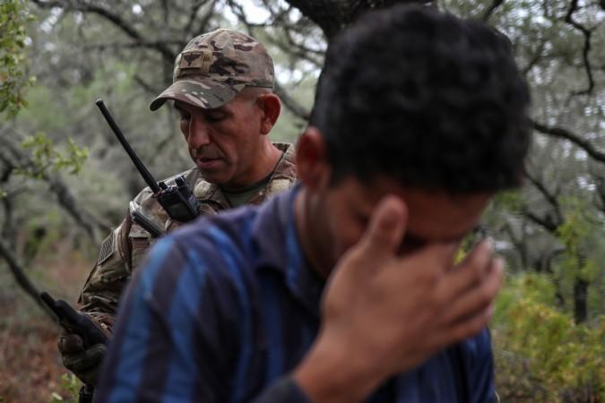 A member of the Border Patrol Search apprehends an illegal immigrant. US immigration crackdown