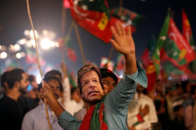 A supporter of Imran Khan, chairman of the Pakistan Tehreek-e-Insaf (PTI), political party, wears a mask and dance on party songs during a campaign rally ahead of general elections in Karachi, Pakistan July 22, 2018. PTI supporter celebrates ahead of Pakistan elections