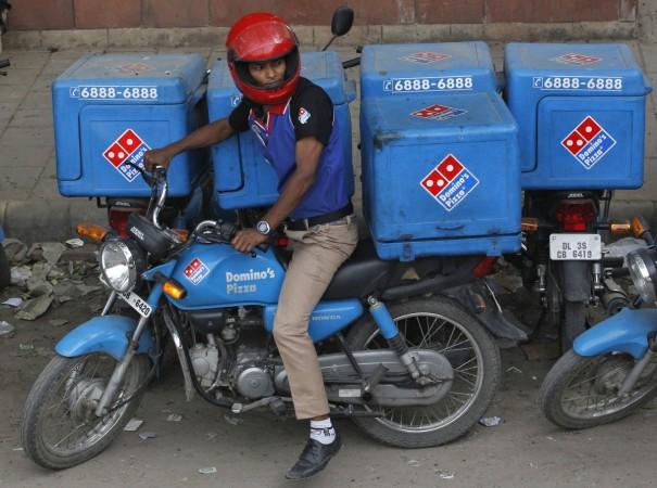 An employee rides a motorcycle to deliver Domino's Pizza to its customers in New Delhi May 14, 2013. An employee rides a motorcycle to deliver Domino's Pizza