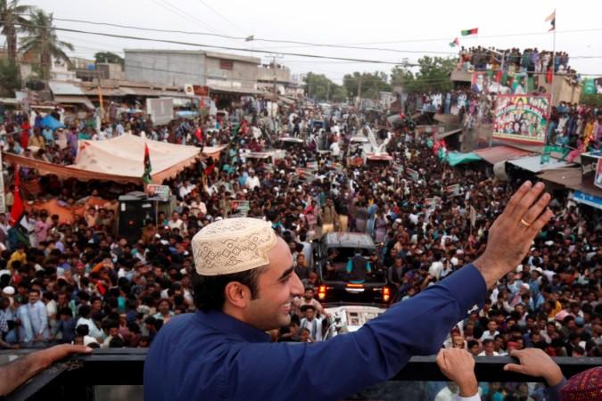 Bilawal Bhutto Zardari, chairman of the Pakistan People's Party (PPP), wearing a Sindhi topi hat, waves to supporters from the roof of his bullet-proof bus, during a campaign rally ahead of general elections in District Thatta, Pakistan on July 2, 2018. Bilawal Bhutto Zardari