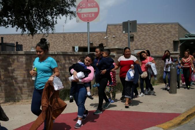 Undocumented immigrant families walk from a bus depot to a respite center after being released from detention in McAllen, Texas US immigration row
