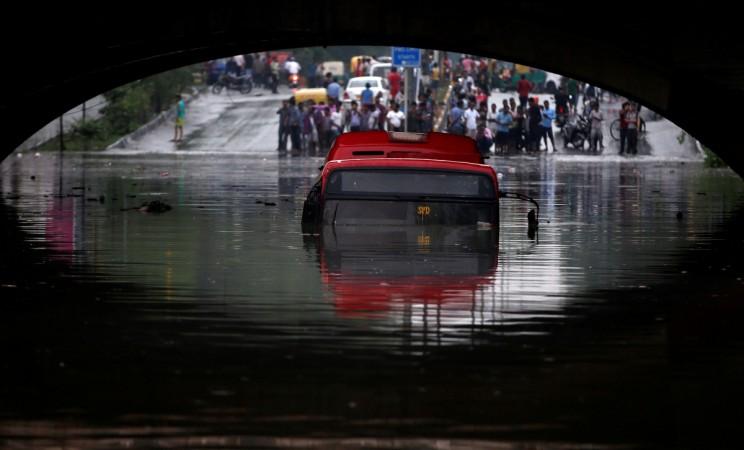 A bus is seen submerged on a flooded road under a railway bridge after heavy rains in New Delhi, India, July 13, 2018. Submerged bus in Delhi floods