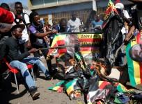Supporters of the opposition Movement for Democratic Change party (MDC) burn an election banner