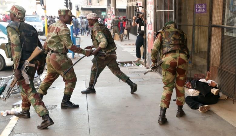 Soldiers beat a supporter of the opposition Movement for Democratic Change (MDC) outside the party's headquarters as they await election results in Harare, Zimbabwe, August 1, 2018 Soldiers beat a supporter of the opposition Movement for Democratic Change