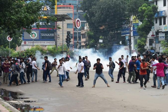 Bangladeshi students stand on a road amidst tear gas during clashes with the police during a student protest in Dhaka on August 5, 2018 Bangladesh protests