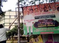 An illegal hoarding promoting the Congress party being torn down by the BBMP