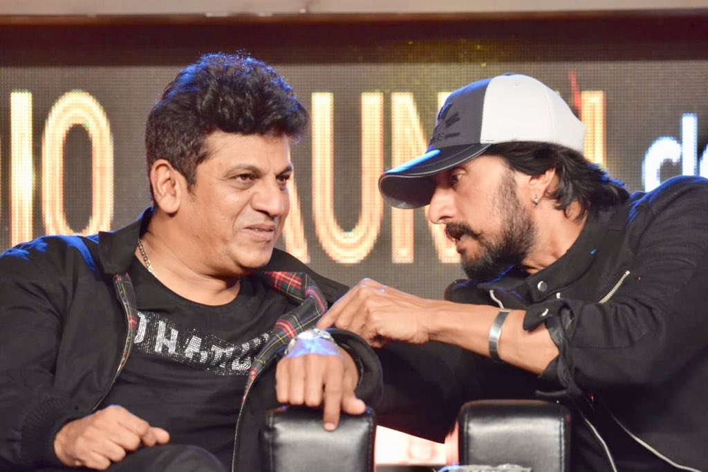 A candid moment between Shivaraj Kumar and Sudeep at The Villain music-release function. The Villain Audio Launch