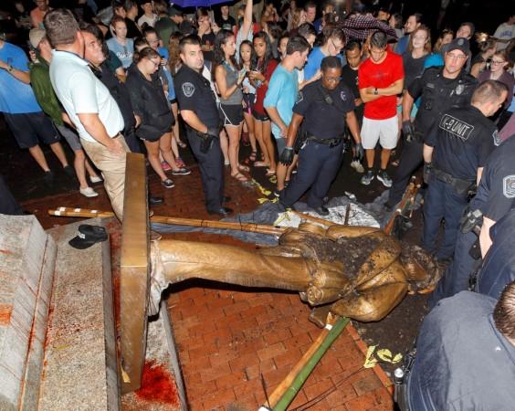The statue on the ground with dirt on it confederate statue
