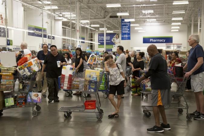 Shoppers with heavily weighted shopping carts wait in line to purchase supplies for Hurricane Lane Hurricane Lane
