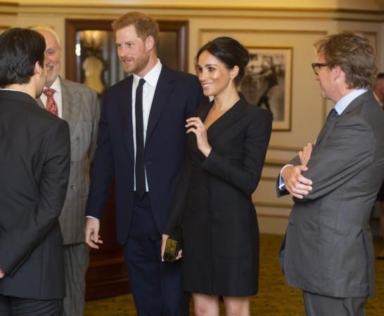 Prince Harry, Duke of Sussex and Meghan, Duchess of Sussex speak with writer Lin Manuel Miranda and others from Sentibale as they attend a gala performance of 'Hamilton' in support of Sentebale at Victoria Palace Theatre on August 29, 2018 in London, England. Meghan Markle tuxedo dress