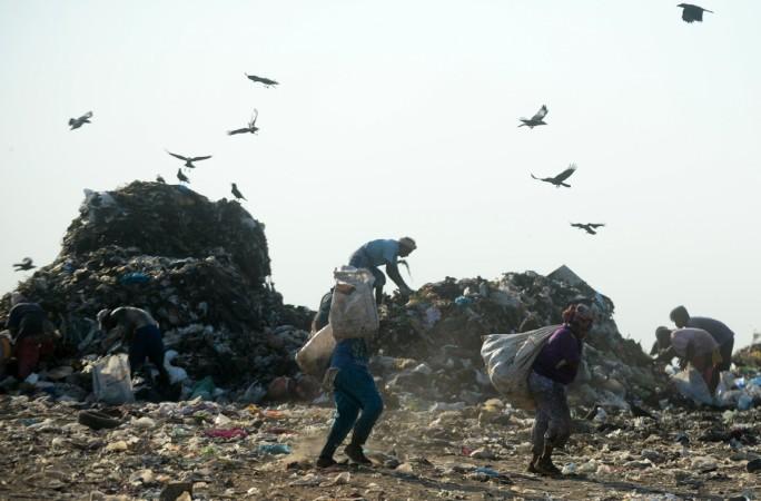 Indian ragpickers work in a landfill site on the outskirts of Chennai on May 11, 2018. landfill