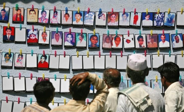 Visitors look at pictures of Godhra riot victims at an exhibition Godhra riots 2002