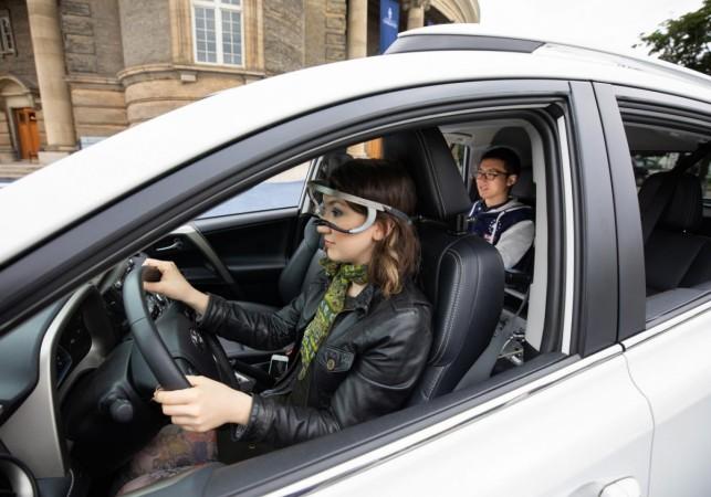 Engineering researcher Nazli Kaya, in the driver's seat, wears the eye-tracking device used to accurately assess where drivers were looking when turning at intersections. eye-tracking device