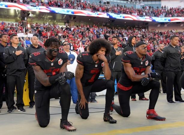 San Francisco 49ers outside linebacker Eli Harold (58), quarterback Colin Kaepernick (7) and free safety Eric Reid (35) kneel in protest during the playing of the national anthem before a NFL game against the Arizona Cardinals in Santa Clara, California, Oct 6, 2016 kaepernick kneeling
