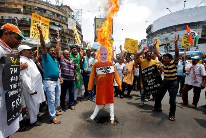 Supporters of India's main opposition Congress party shout slogans as they burn an effigy depicting India's Prime Minister Narendra Modi during a protest against the rise in fuel prices fuel price