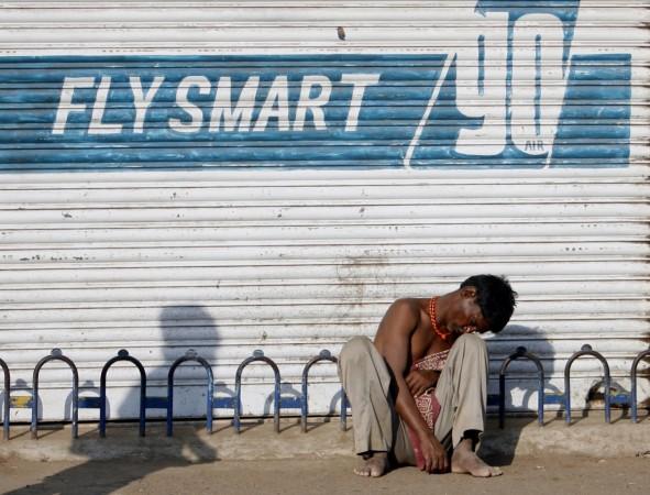 An unemployed migrant worker sits on a pavement in Mumbai