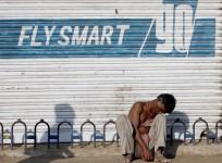 An unemployed migrant worker sits on a pavement in Mumbai