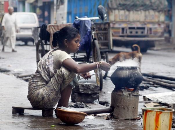 Unemployed Rupa Kaha prepares her lunch beside a busy street in Calcutta. Unemployed Rupa Kaha prepares her lunch beside a busy street in Calcutta.