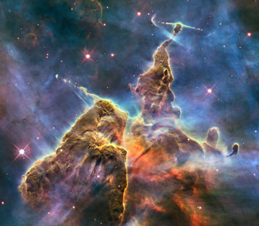 Small portion of one of the largest seen star-birth regions in the galaxy, the Carina Nebula. Towers of cool hydrogen laced with dust rise from the wall of the nebula Pillars of creation