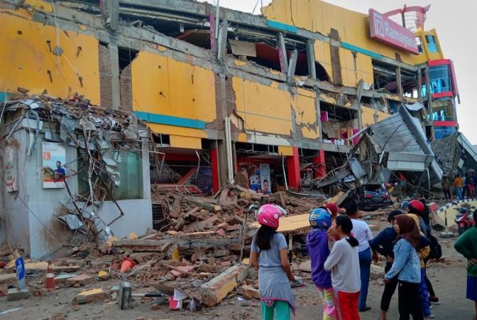 Residents stand in front of a damaged shopping mall after an earthquake hit Palu Indonesia Tsunami