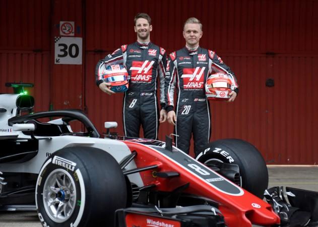 Romain Grosjean (L) and Kevin Magnussen pose by their new HAAS F1 Team's car Haas F1 Team
