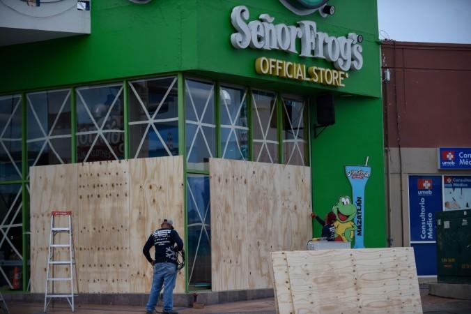 Workers protect a storefront with wood panels at the Mazatlan port in Sinaloa state, Mexico, on October 22, 2018, before the arrival of Hurricane Willa. Hurricane Willa