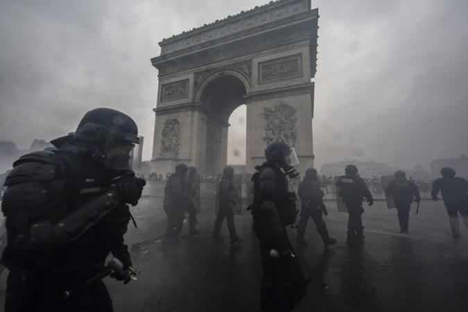Teargas surrounds riot police as they clash with protesters during a 'Yellow Vest' demonstration near the Arc de Triomphe on December 1, 2018 in Paris, France. Paris Riots