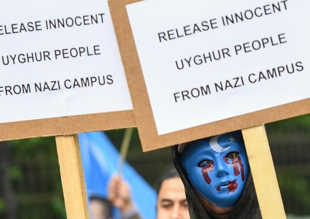 A person wearing a blue mask with tears of blood takes part in a protest march of ethnic Uighurs asking for the European Union to call upon China to respect human rights in the Chinese Xinjiang region. China Uighur Muslims
